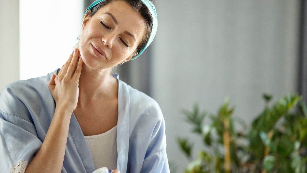 Woman applying skin care to her neck