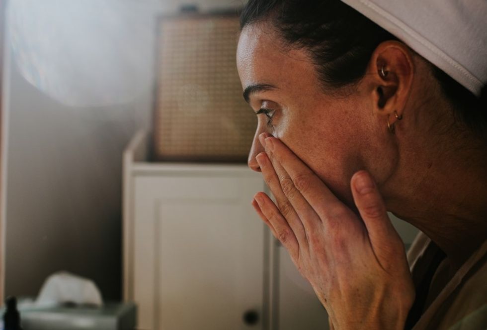 WOMAN APPLYING SKIN CARE