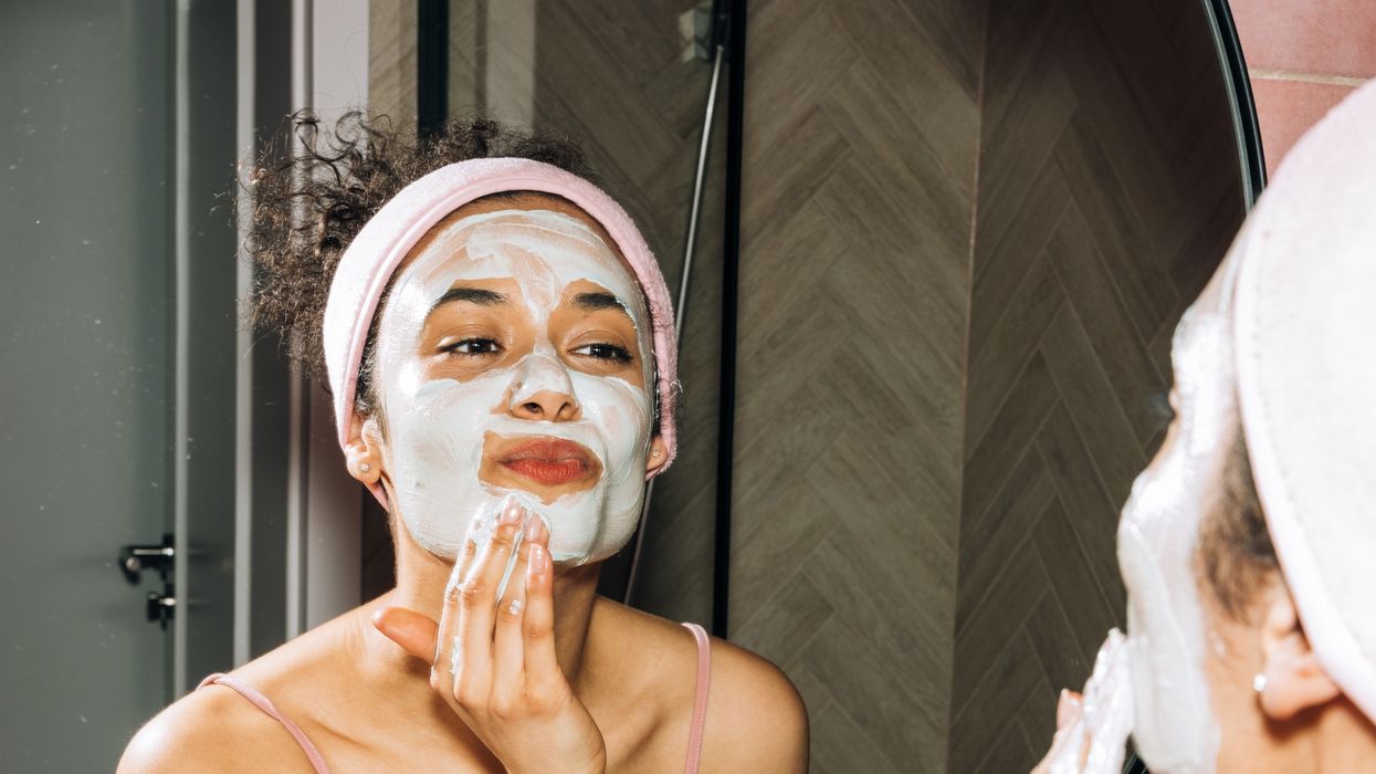Woman applying skincare in mirror