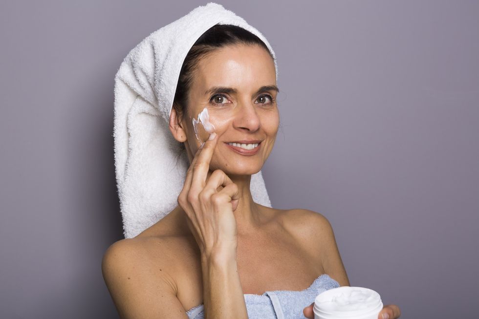 Woman applying sunscreen to her face