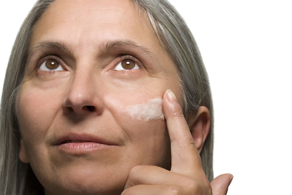 Woman applying tinted moisturiser