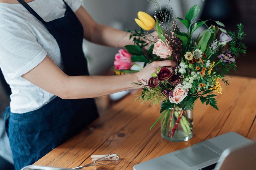 Woman arranging vase of flowers