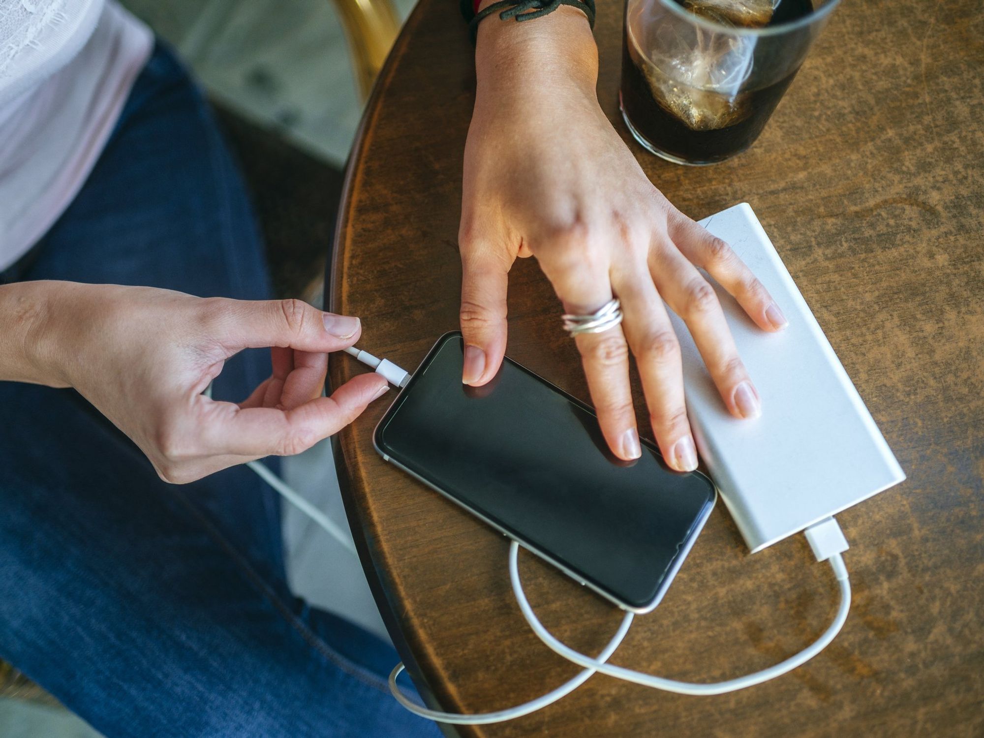 Woman charging phone using portable charger
