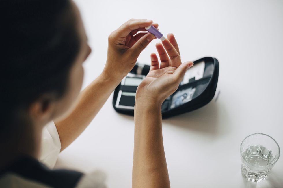 WOMAN CHECKING BLOOD SUGAR