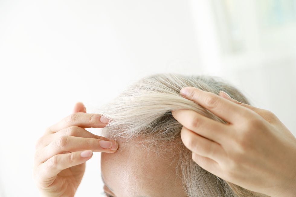 Woman checking hairline stock image