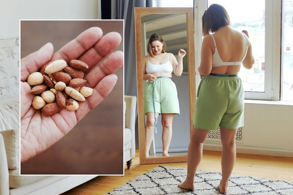 Woman checking waistline and nuts in hand