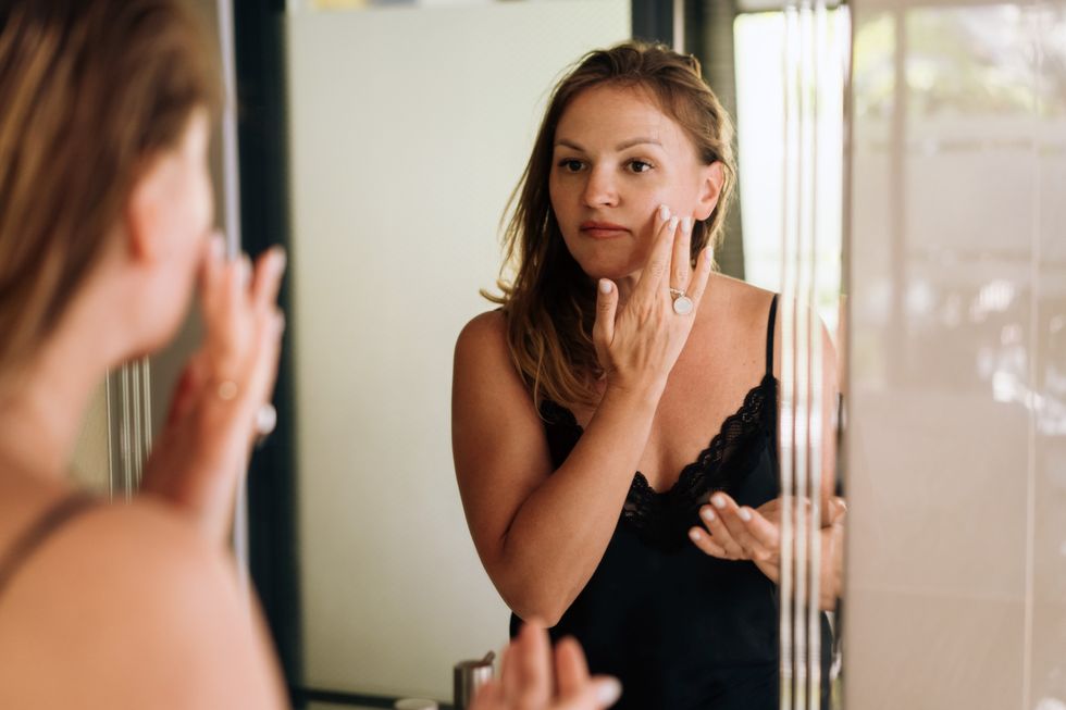 Woman doing skin care in the mirror