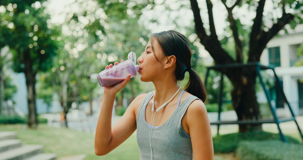 Woman drinking a protein shake in a park