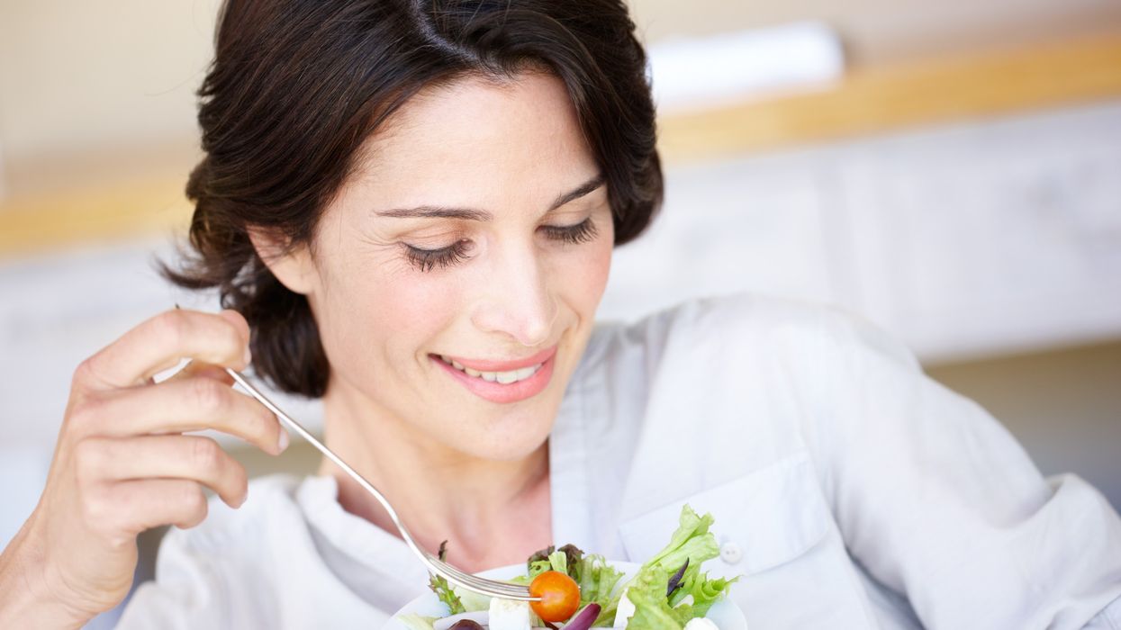 Woman eating a salad with leafy vegetables