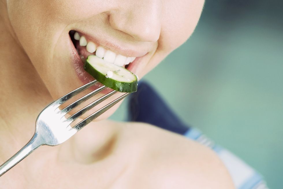 Woman eating cucumber
