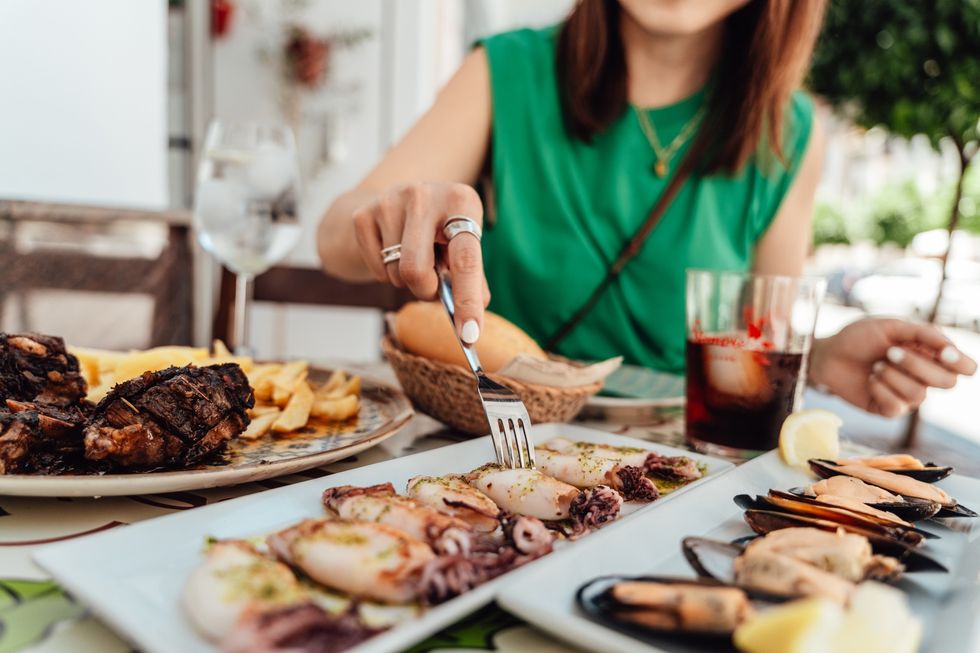 Woman eating Spanish food outside