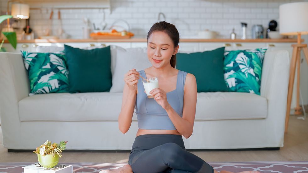 Woman eating yoghurt with fruit