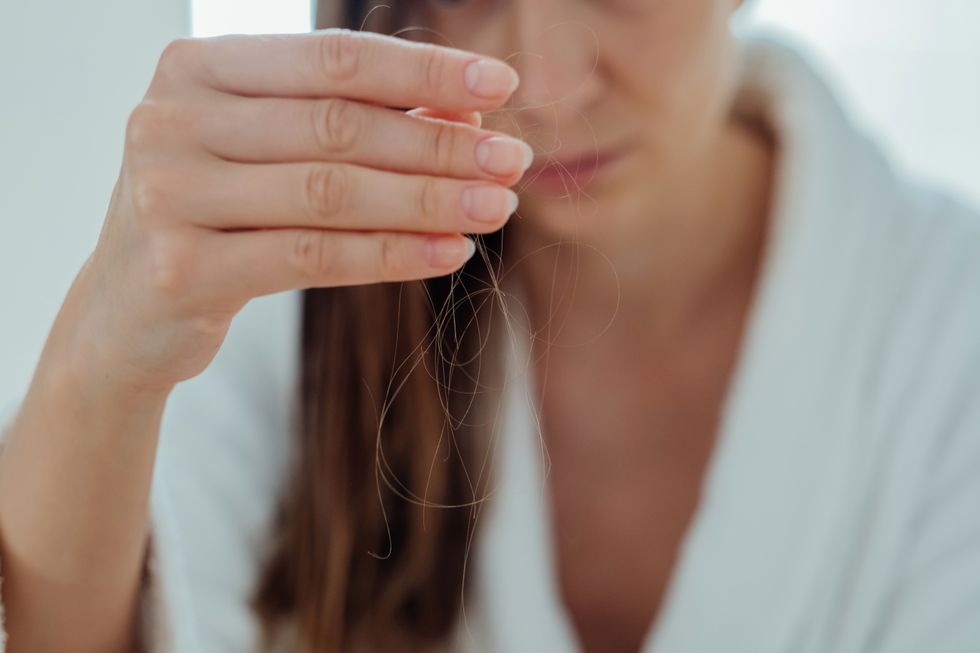 Woman examining hair loss