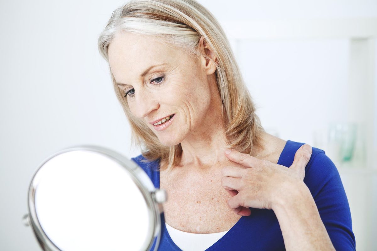 Woman examining her neck in mirror