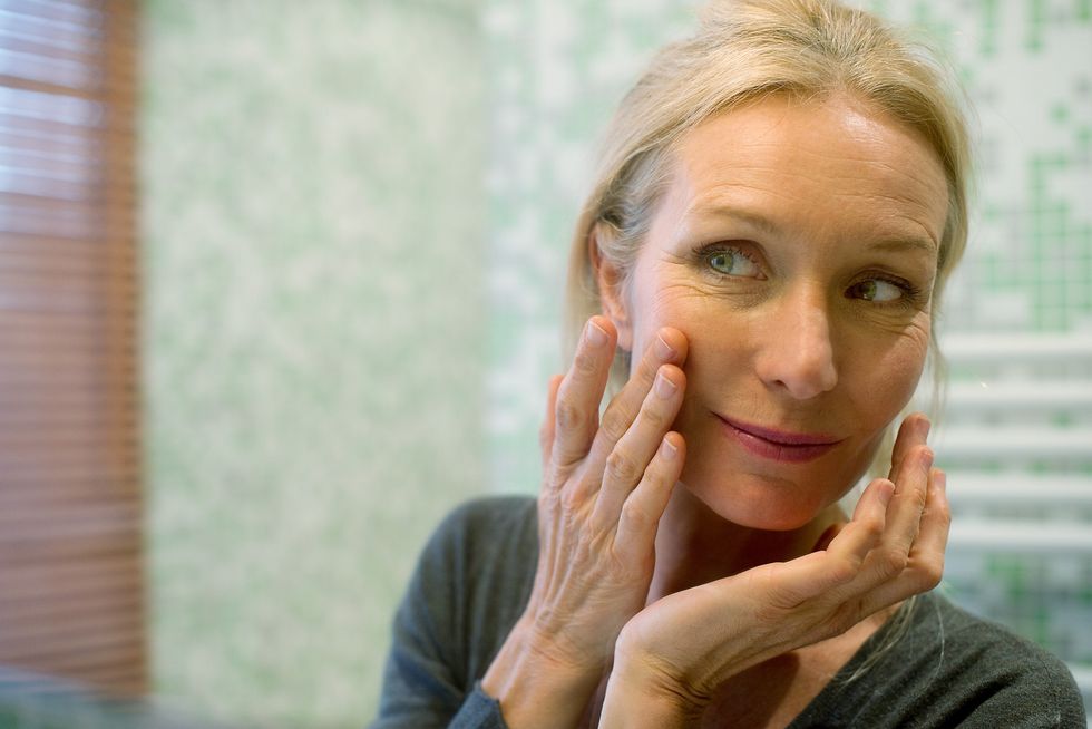 Woman examining her skin in mirror