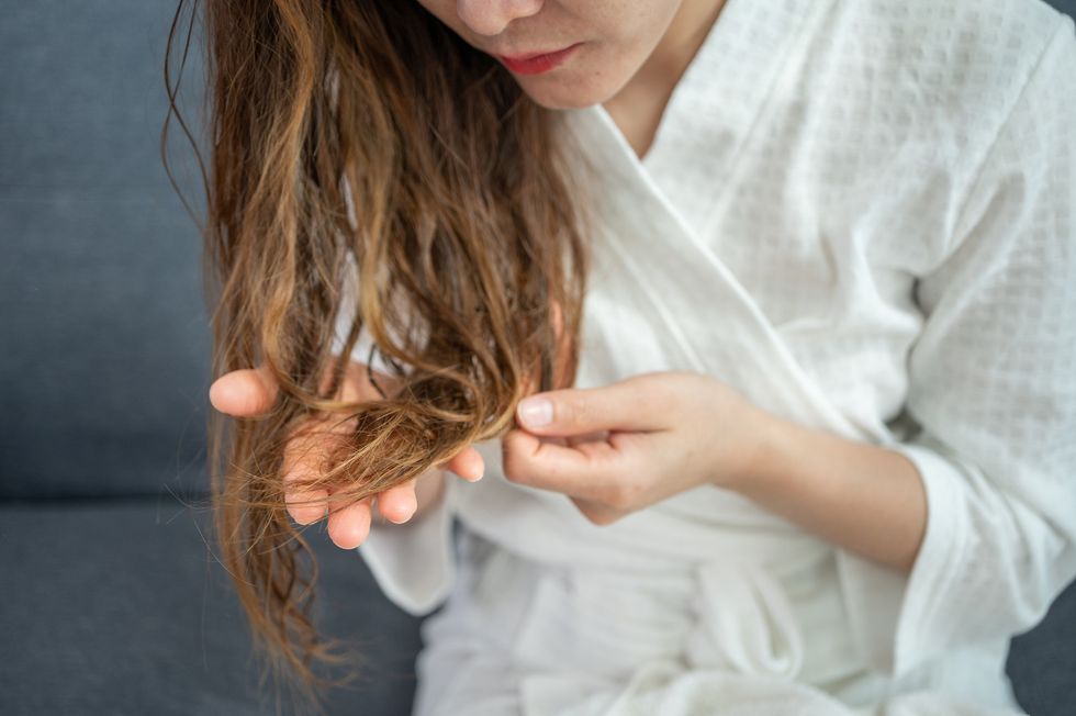 Woman examining the ends of her hair