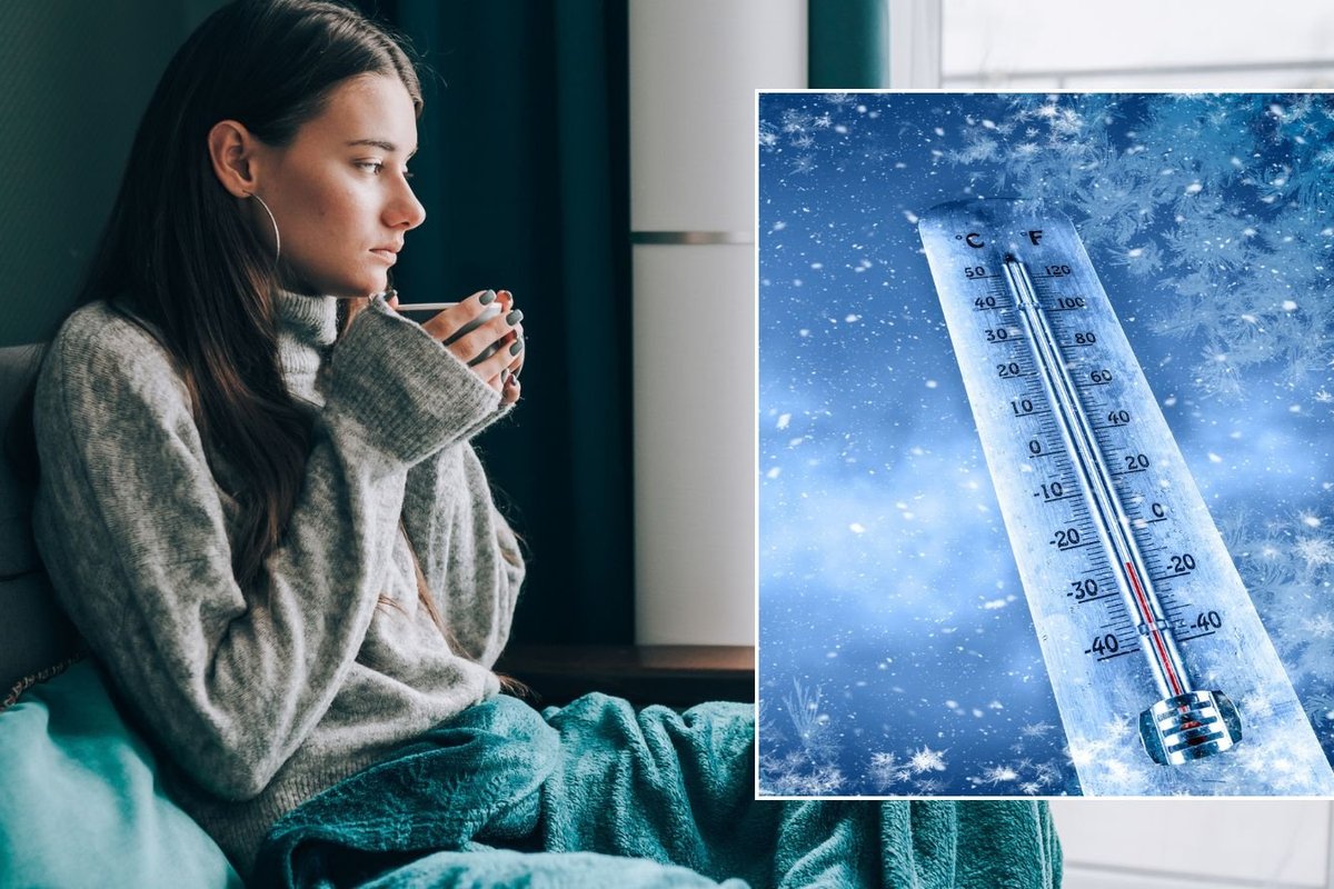 Woman feeling cold at home and icy thermometer