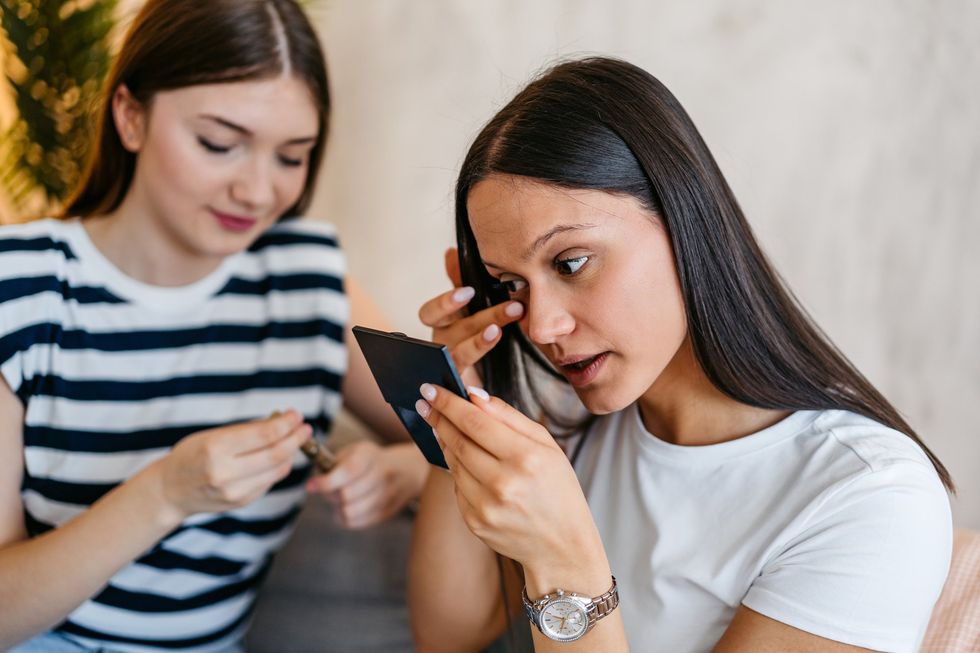 Woman fixing her smudged mascara