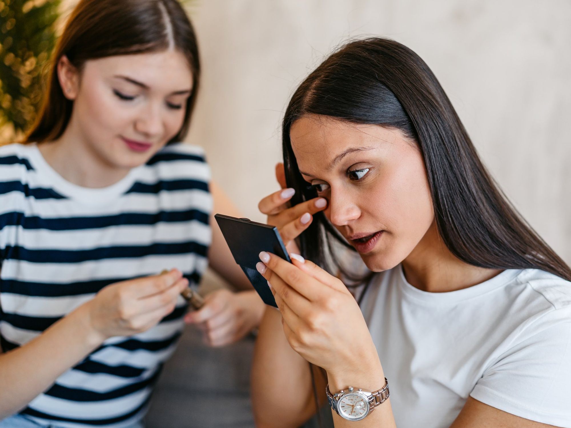 Woman fixing her smudged mascara