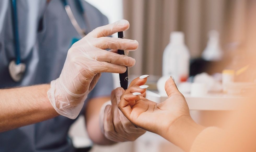 Woman getting finger pricked to test her blood sugar levels