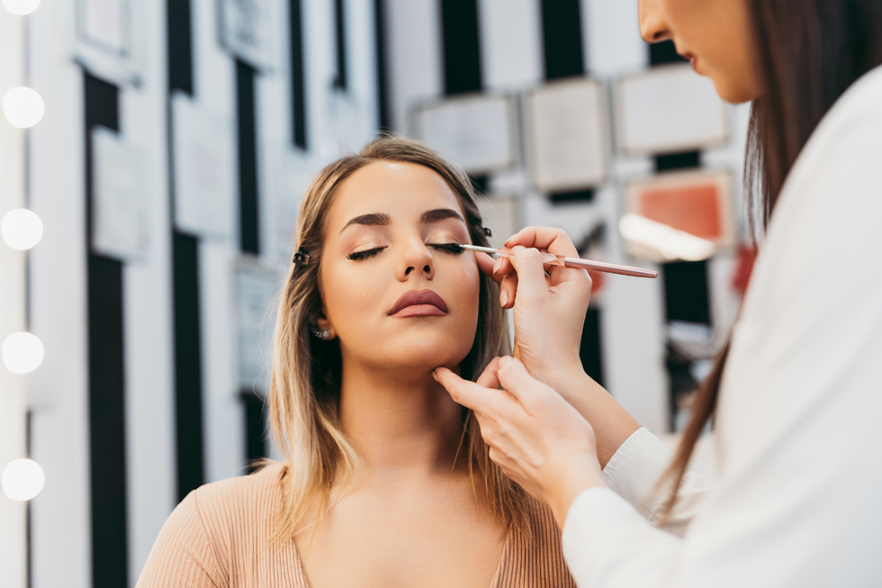 Woman getting her makeup done by another artist