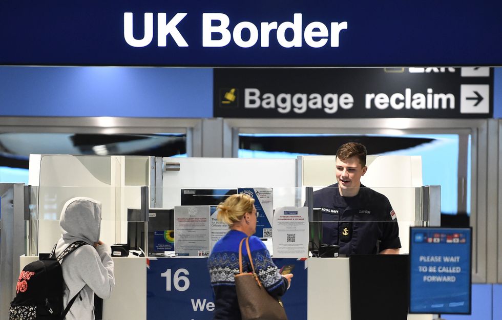 Woman giving her passport to UK border control