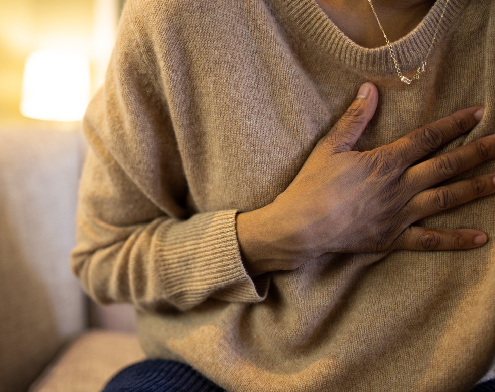 Woman gripping chest tightly