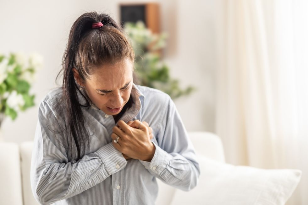 Woman having a heart attack, clutching her chest