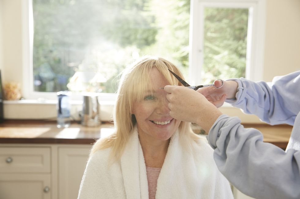Woman having bangs cut into her hair