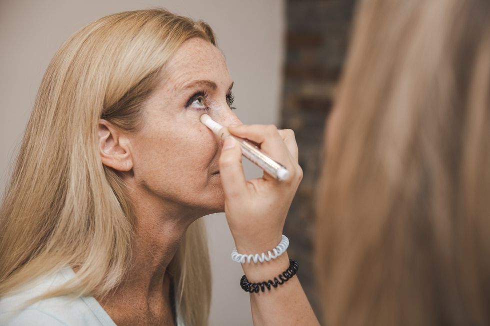 Woman having concealer applied under her eyes