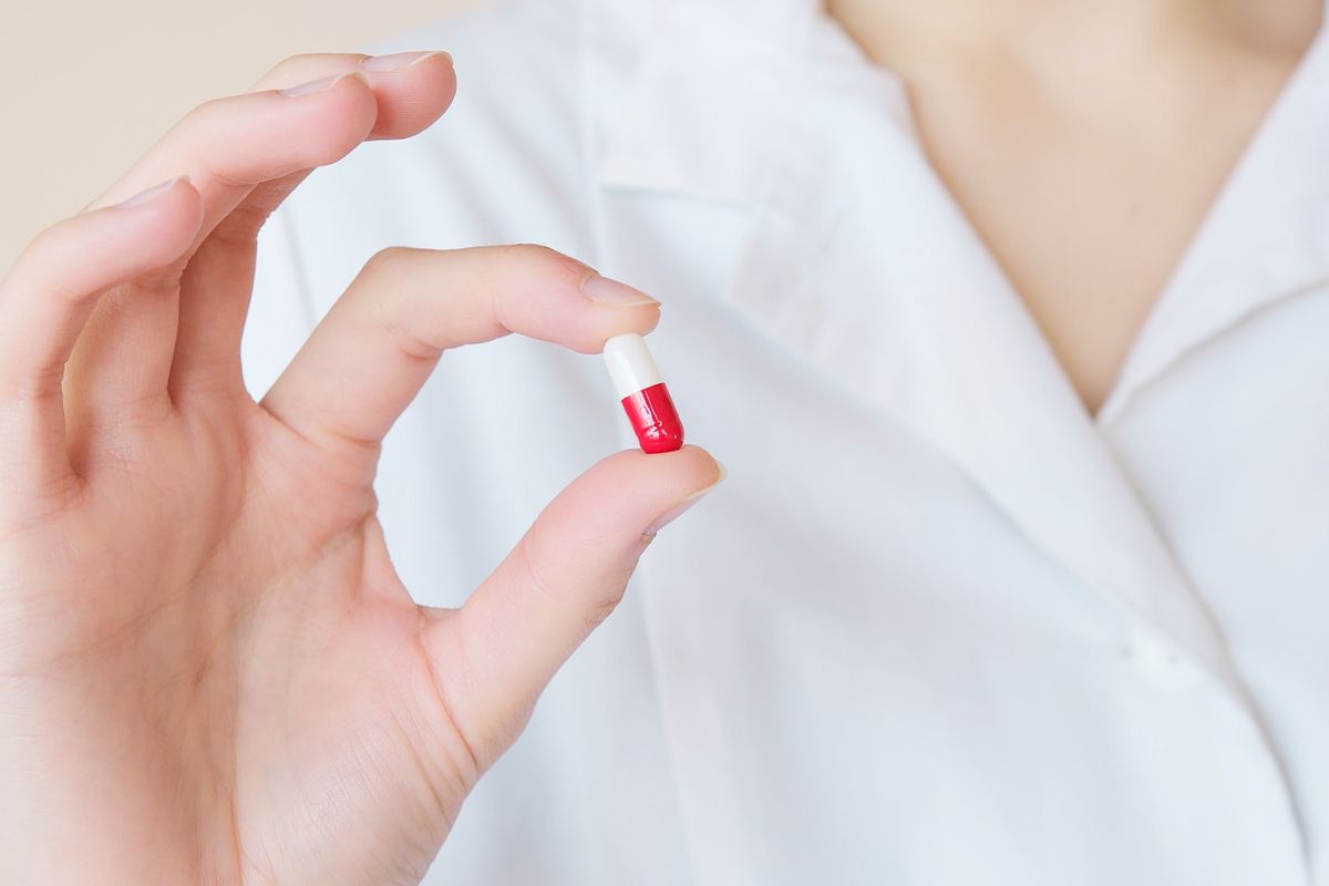 Woman holding a pill