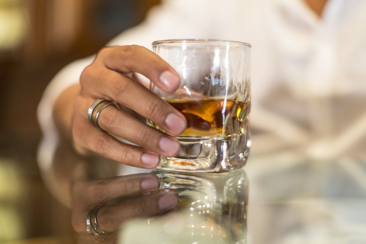 Woman holding glass of whisky