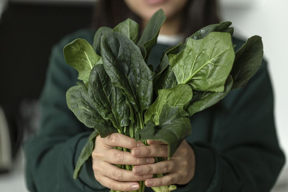 Woman holding handful of spinach