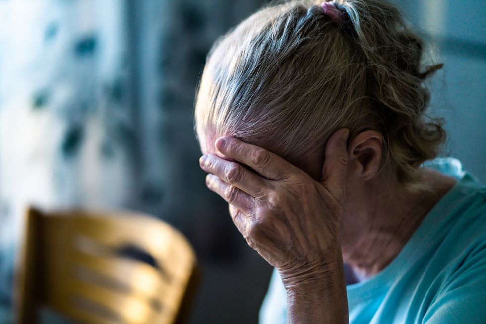 Woman holding head in her hands