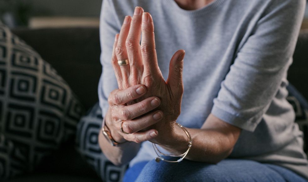 Woman holding her hand that's in pain