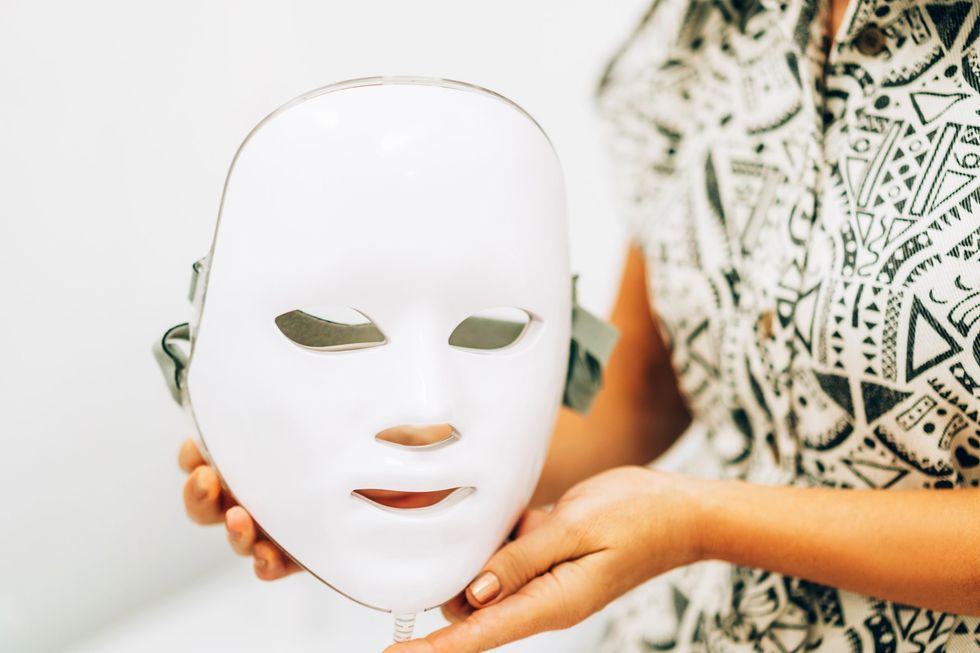 Woman holding LED skin care mask
