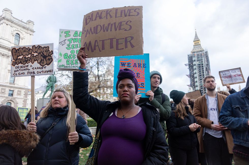 Woman holding placard during protest saying 'black lives and midwives matter'