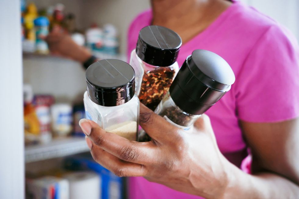 Woman holding spices including garlic powder