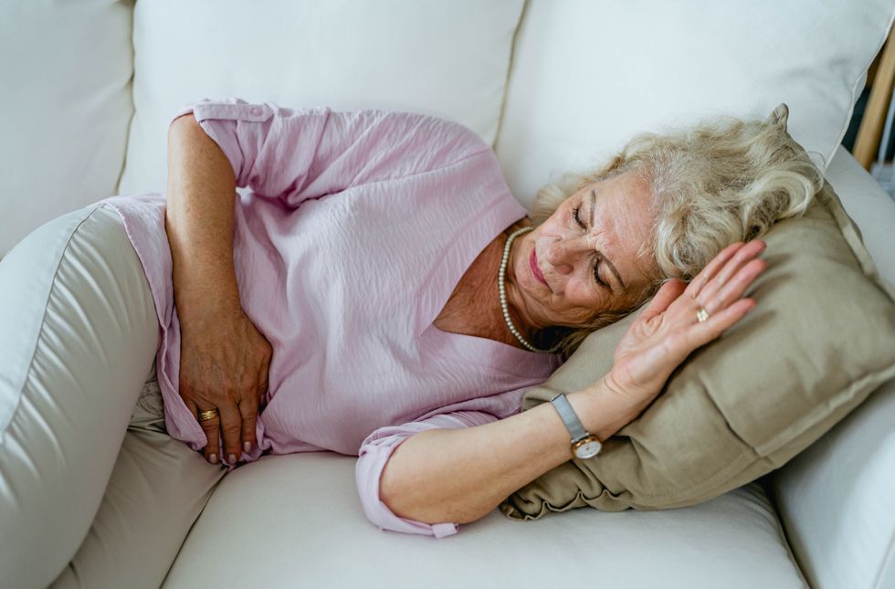WOMAN HOLDING STOMACH