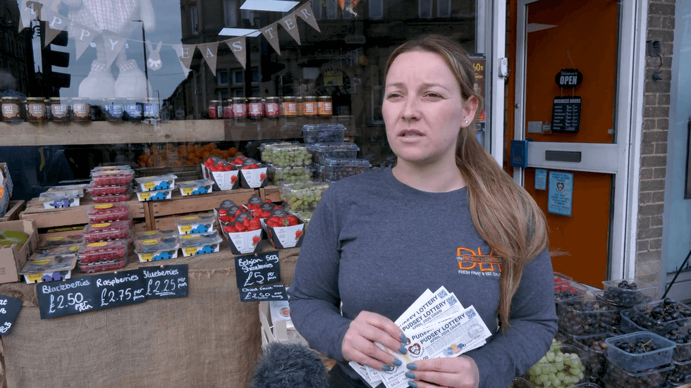 Woman holds Pudsey Pounds Lottery tickets