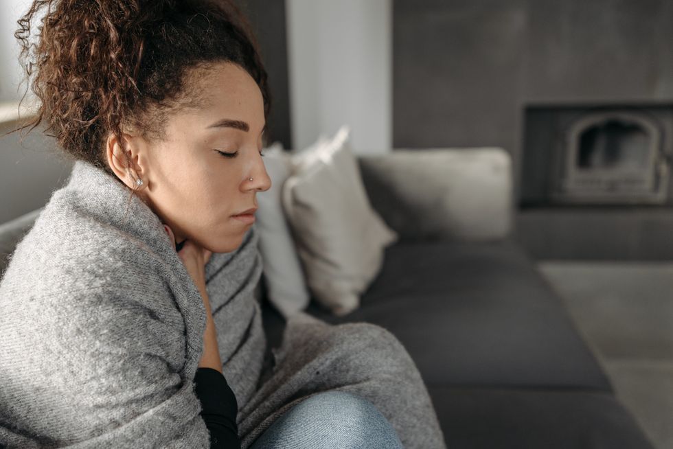 Woman in blanket at home