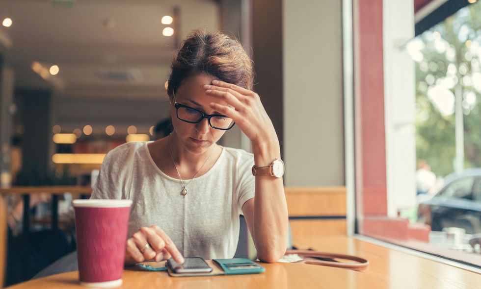 Woman in coffee shop looking at app