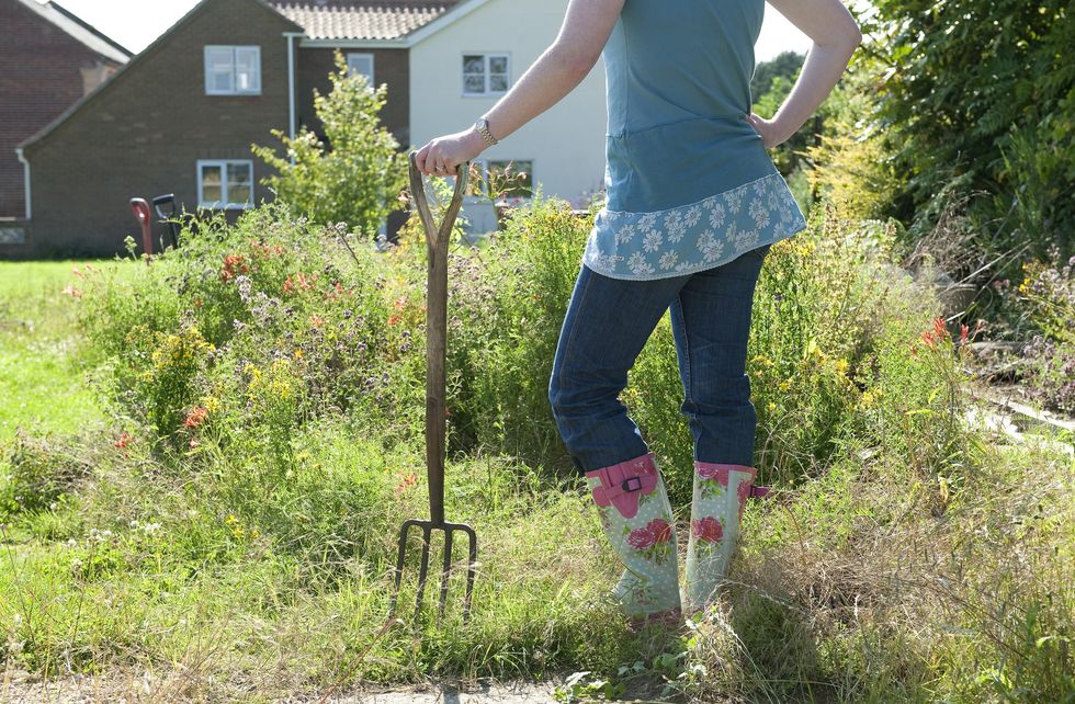 Woman in overgrown garden