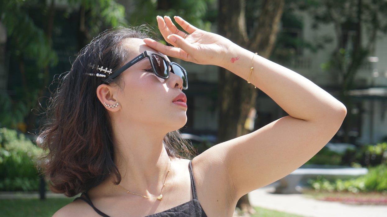 Woman in sun touching face