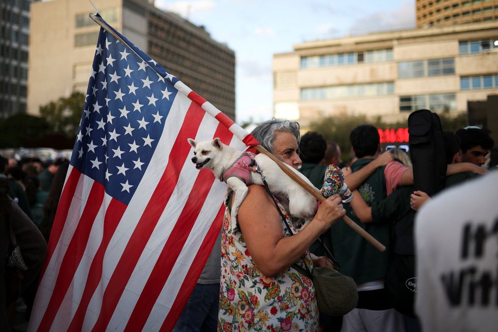 Woman in Tel Aviv brandishing US flag to celebrate first step in peace deal