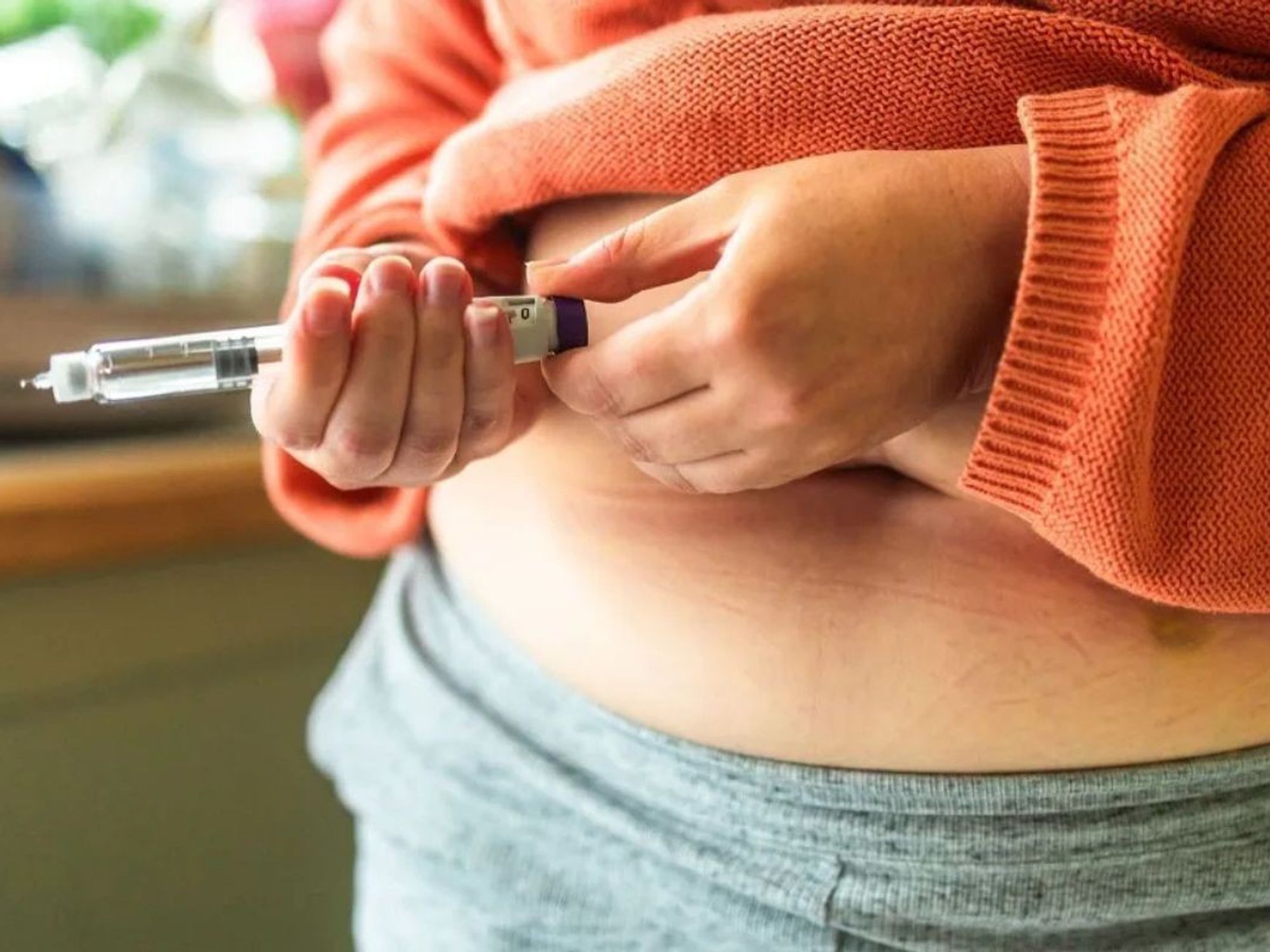 Woman injecting her stomach