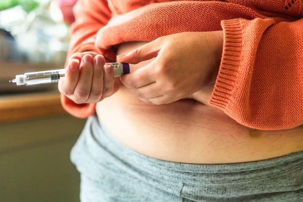Woman injecting her stomach