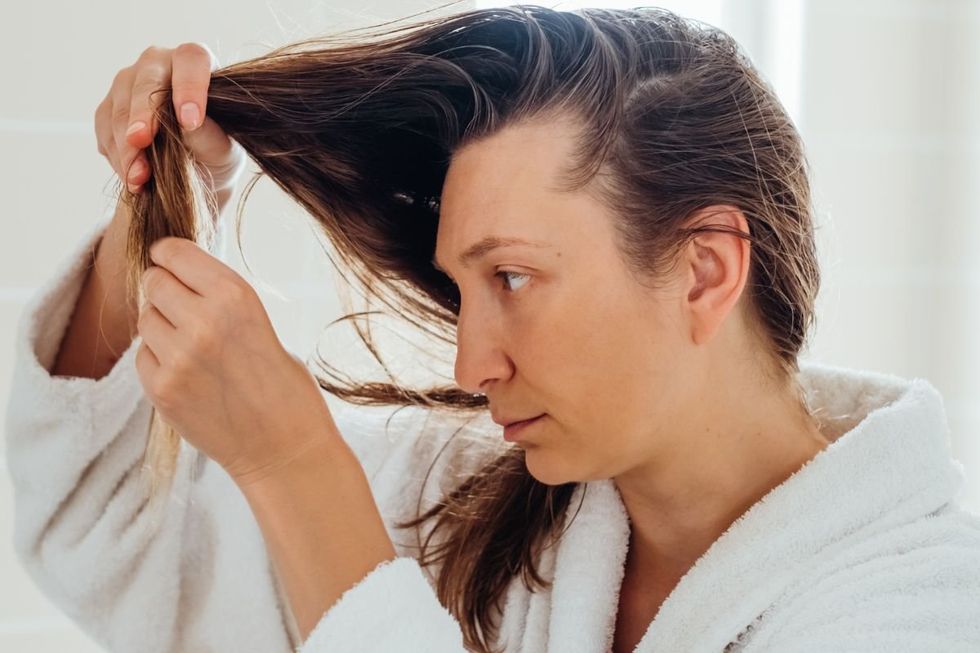 WOMAN INSPECTING HER HAIR