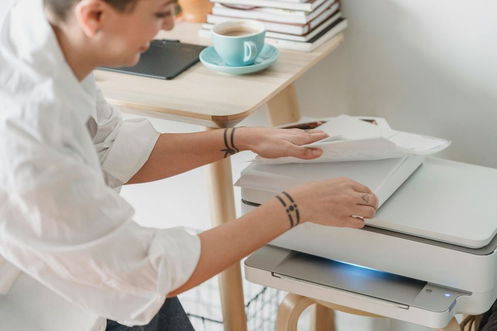 Woman loading paper into a printer