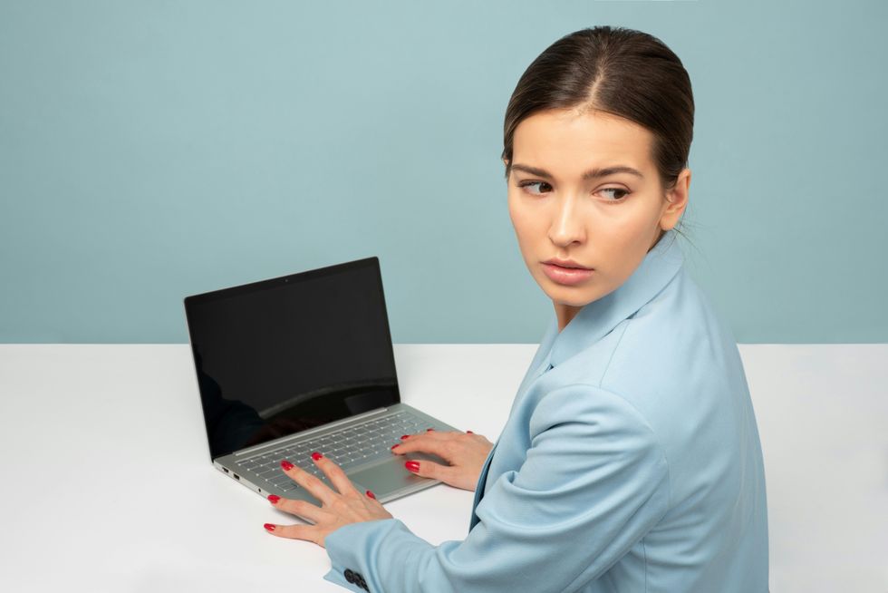 Woman looking behind her with laptop